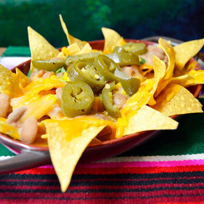 House nachos topped with beans, cheese, jalapeño, and fresh herbs